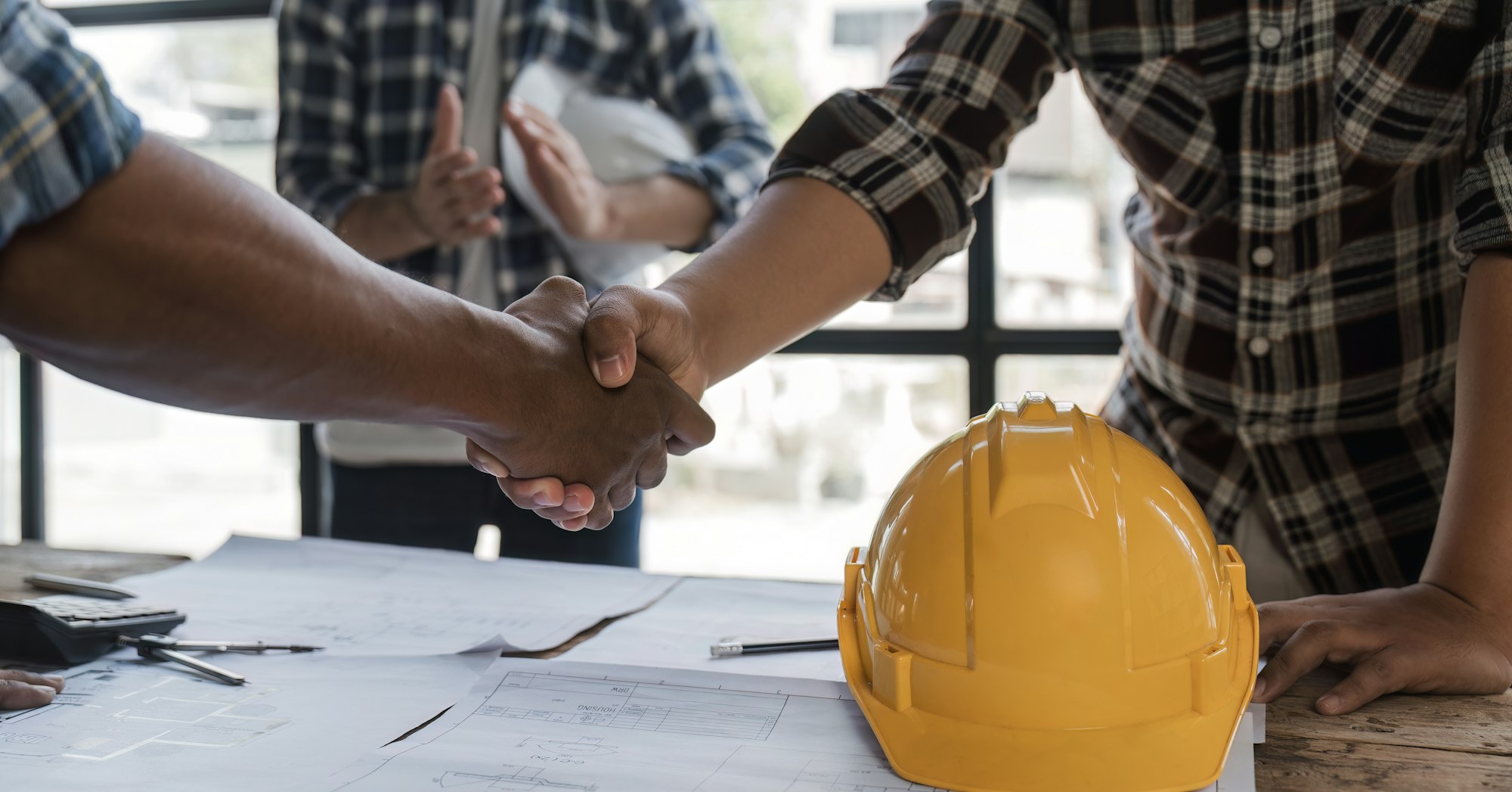 A team of engineers who successfully planned work on a modern home construction project shook hands